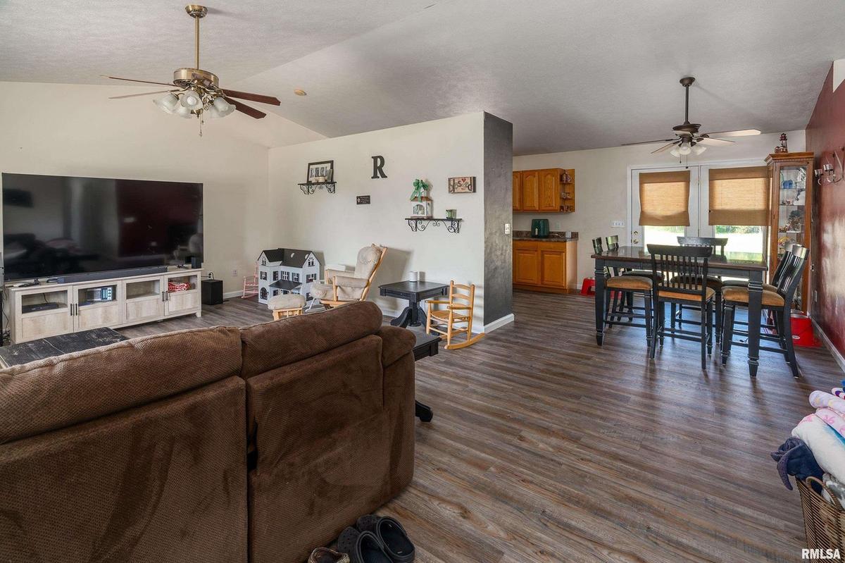 Open living, dining and kitchen area with vaulted ceiling and new laminate flooring at 1400 Hazel Street, Johnston City
